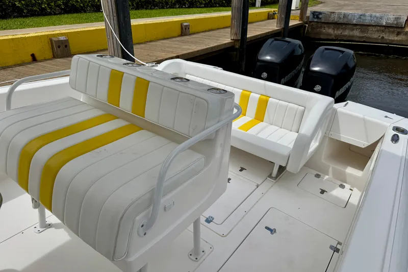 Slide: The Image of 2013 Intrepid 300 Center Console boat with yellow-striped seating and dual Mercury engines. - 10