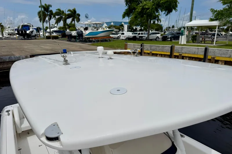 Slide: The Image of 2013 Intrepid 300 Center Console boat docked at a marina with palm trees. - 14