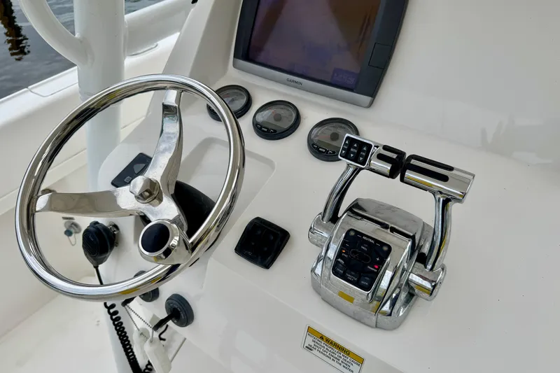 Slide: The Image of Control panel of a 2013 Intrepid 300 Center Console boat with steering wheel and gauges. - 18