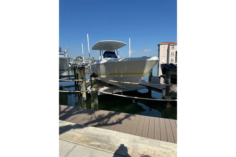 Slide: The Image of 2013 Intrepid 300 Center Console boat docked at marina under clear blue sky. - 26