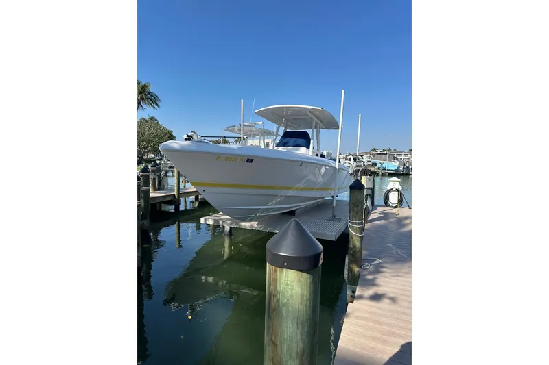 Slide: The Image of 2013 Intrepid 300 Center Console boat docked at marina under clear blue sky. - 28