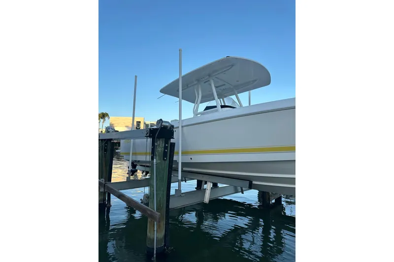Slide: The Image of 2013 Intrepid 300 Center Console boat on lift, docked by calm waters. - 29
