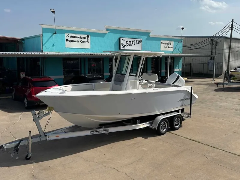 The Image of Sailfish 232 CC 2026 on trailer outside boat repair shop. - 1