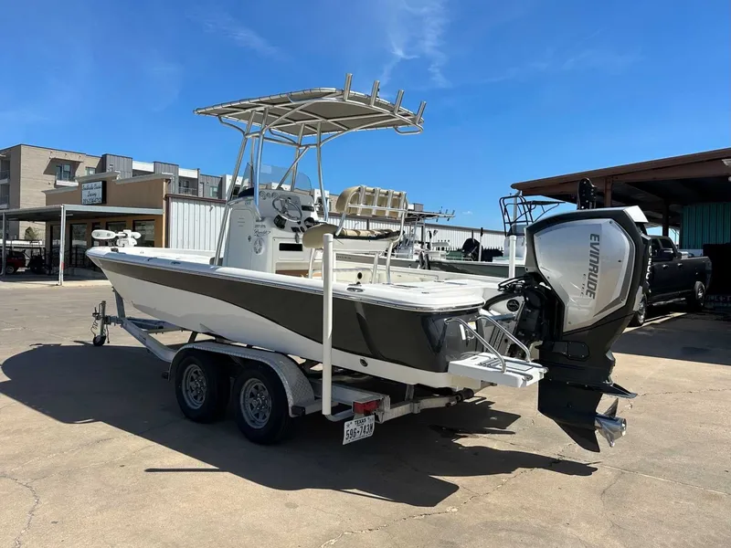 Slide: The Image of 2019 NauticStar 227XTS boat with Evinrude motor on trailer. - 10