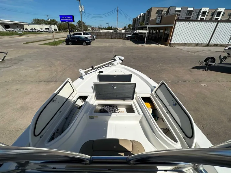 Slide: The Image of 2019 NauticStar 227XTS boat with open storage compartments on a parking lot. - 18