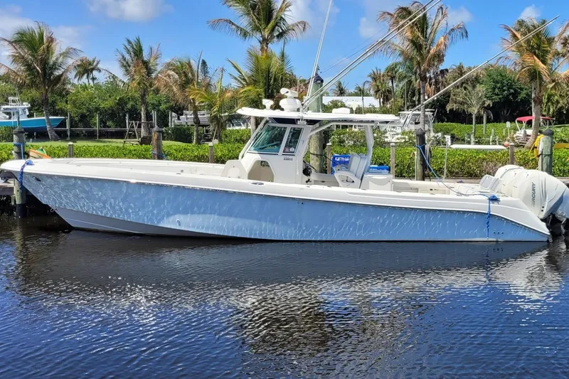The Image of 2009 Everglades 350 Center Console boat docked by palm trees on a sunny day. - 0