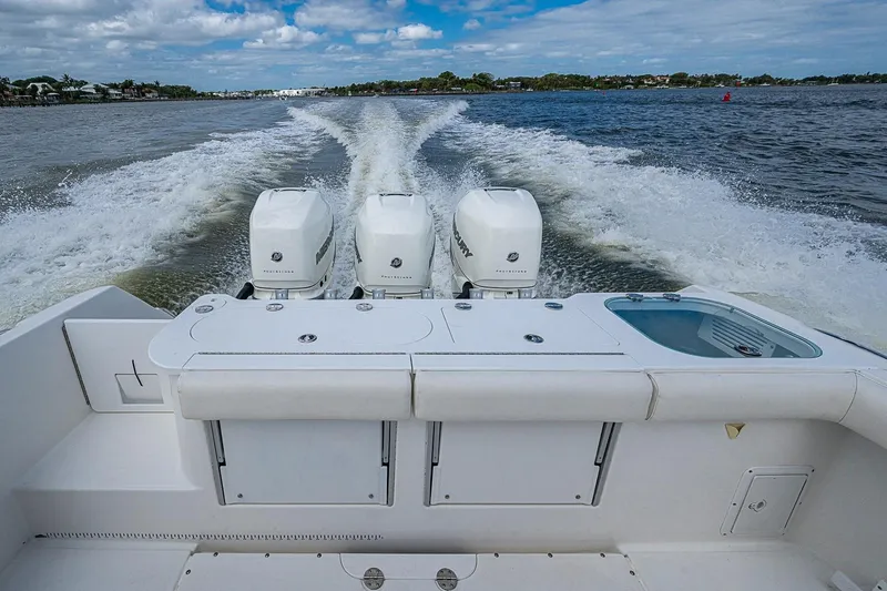 Slide: The Image of 2009 Everglades 350 Center Console boat with triple engines cruising on open water. - 20
