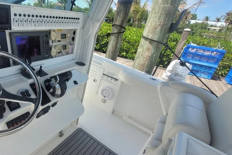 Slide: The Image of 2009 Everglades 350 Center Console boat interior with seating and table on calm water. - 5