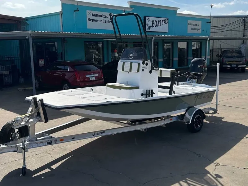The Image of 2026 Freedom PATRIOT boat on trailer outside workshop. - 1