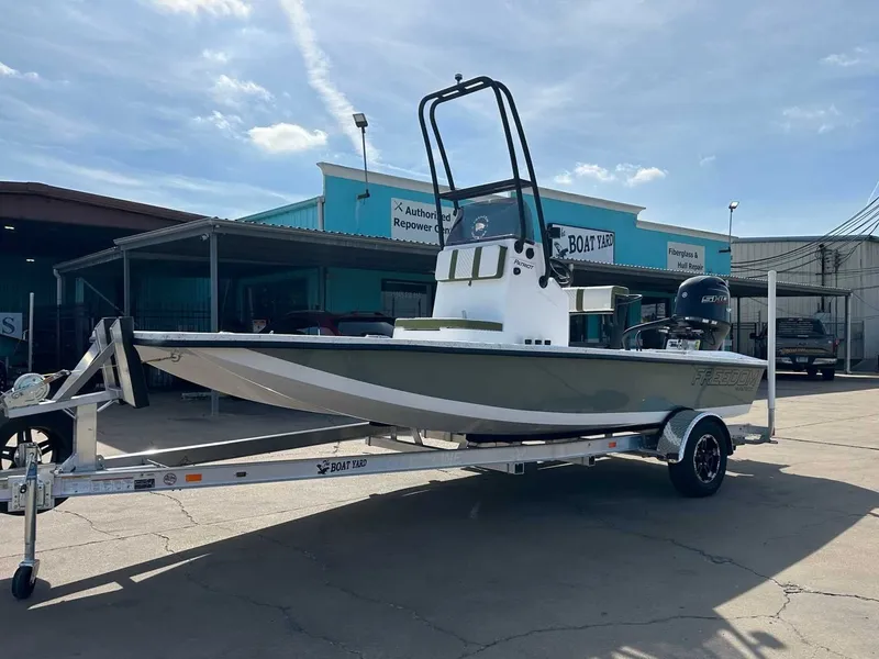 Slide: The Image of 2026 Freedom PATRIOT boat on trailer outside workshop. - 8