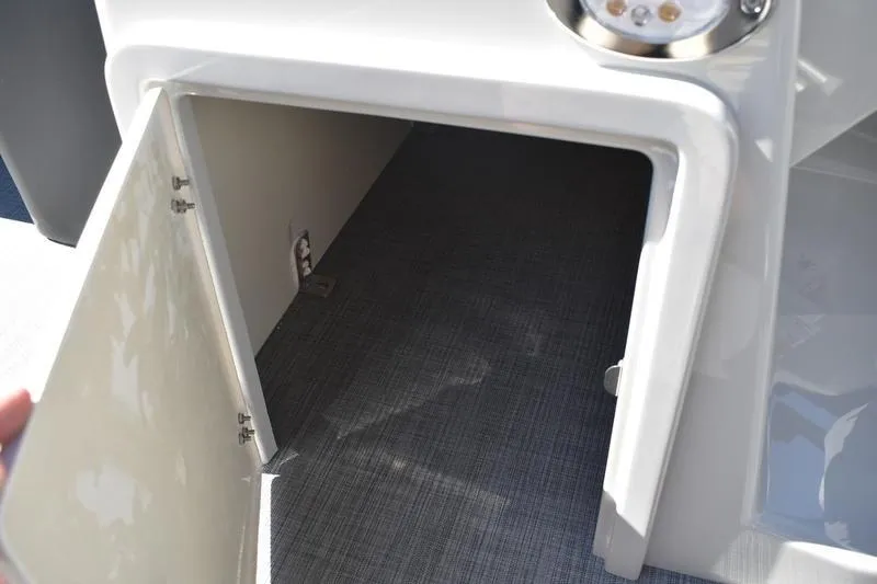 Slide: The Image of Open storage compartment on 2026 Lowe SS 230 boat, featuring a sleek design and carpeted interior. - 26
