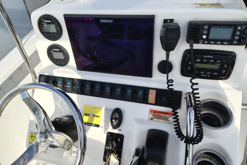 Slide: The Image of 2017 Sea Hunt Triton 188 dashboard with steering wheel, controls, and navigation equipment. - 10