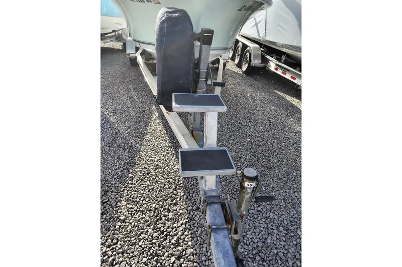 Slide: The Image of 2017 Sea Hunt Triton 188 boat on trailer with step ladder, parked on gravel. - 5