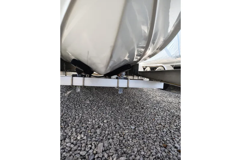 Slide: The Image of 2017 Sea Hunt Triton 188 boat hull on gravel, showcasing trailer support. - 6