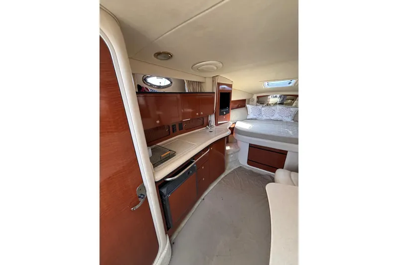 Slide: The Image of Interior of 2003 Sea Ray Sundancer 320 yacht with wood cabinetry and cozy sleeping area. - 12