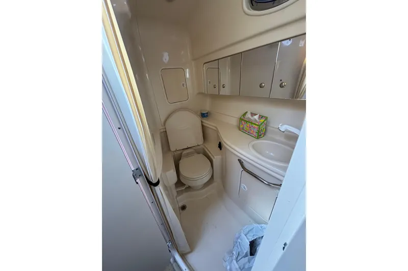 Slide: The Image of 2003 Sea Ray Sundancer 320 bathroom with toilet, sink, and storage cabinets. - 14