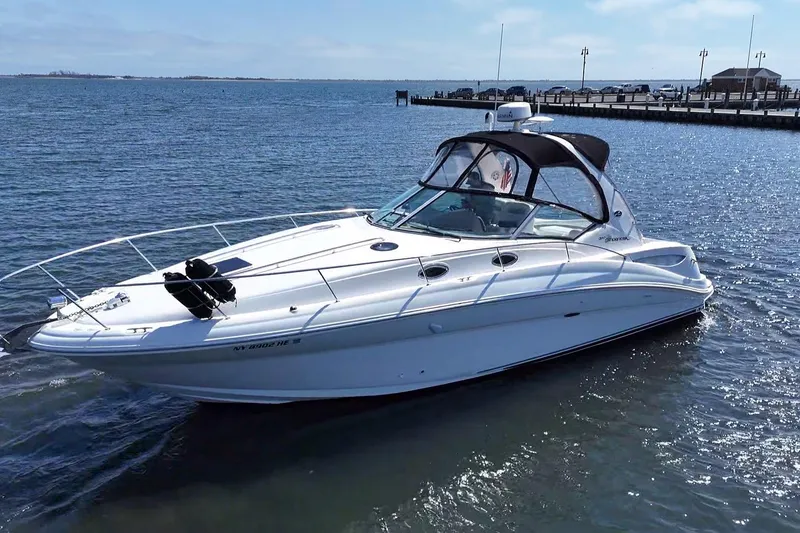 Slide: The Image of 2003 Sea Ray Sundancer 320 yacht on calm water, showcasing sleek design and luxury features. - 3