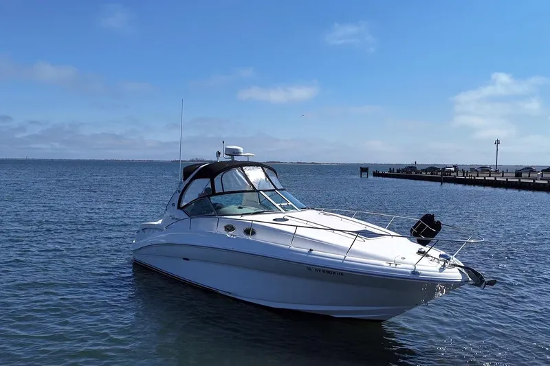 Slide: The Image of 2003 Sea Ray Sundancer 320 yacht on calm water under clear blue sky. - 4