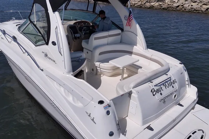 Slide: The Image of 2003 Sea Ray Sundancer 320 boat on water, featuring spacious seating and elegant design. - 5