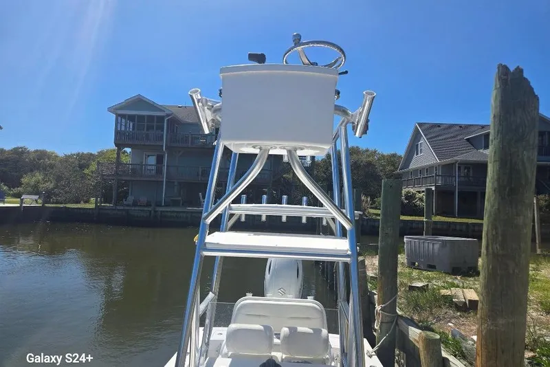 Slide: The Image of 2023 Layton Bay 22 boat docked near waterfront homes under clear blue sky. - 13