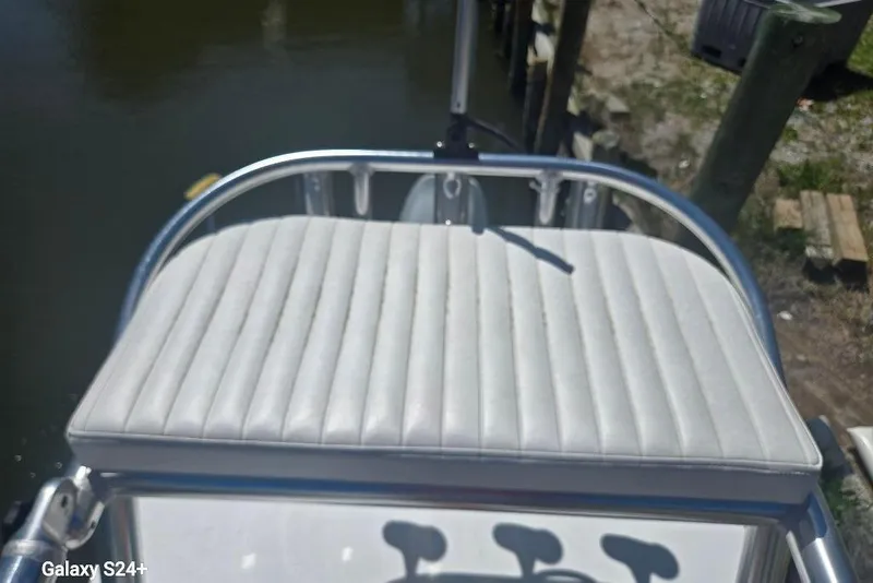 Slide: The Image of 2023 Layton Bay 22 boat seat with white cushioned upholstery, docked by the water. - 15