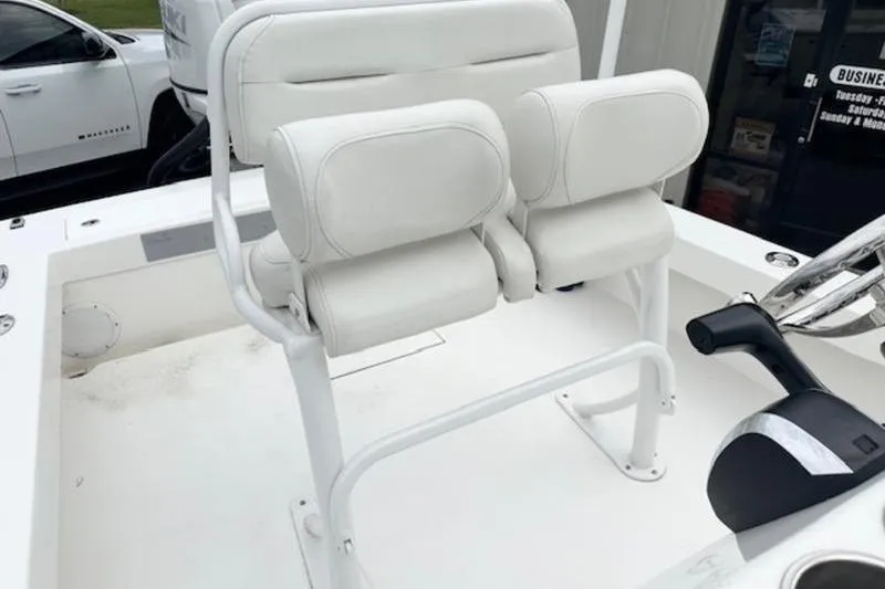 Slide: The Image of 2023 Layton Bay 22 boat with white cushioned seating and steering console. - 17