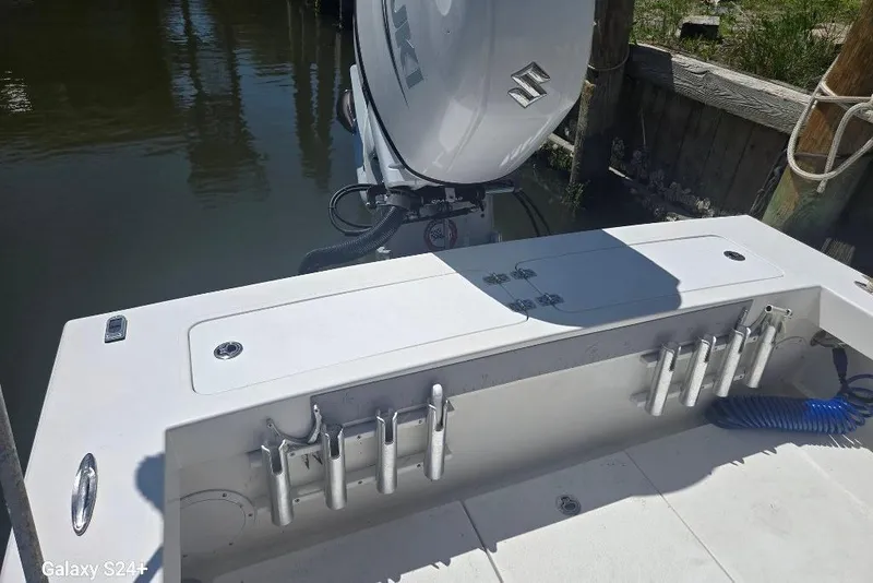 Slide: The Image of 2023 Layton Bay 22 boat with Suzuki outboard motor, docked by wooden posts. - 20