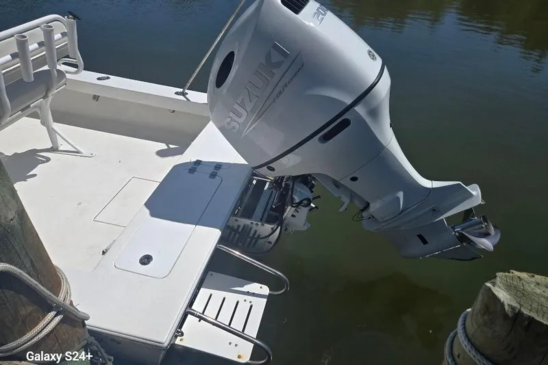 Slide: The Image of 2023 Layton Bay 22 boat with Suzuki outboard motor docked on calm water. - 21