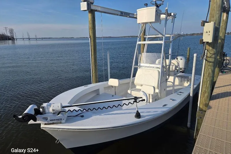 Slide: The Image of 2023 Layton Bay 22 boat docked on calm water with fishing equipment. - 6