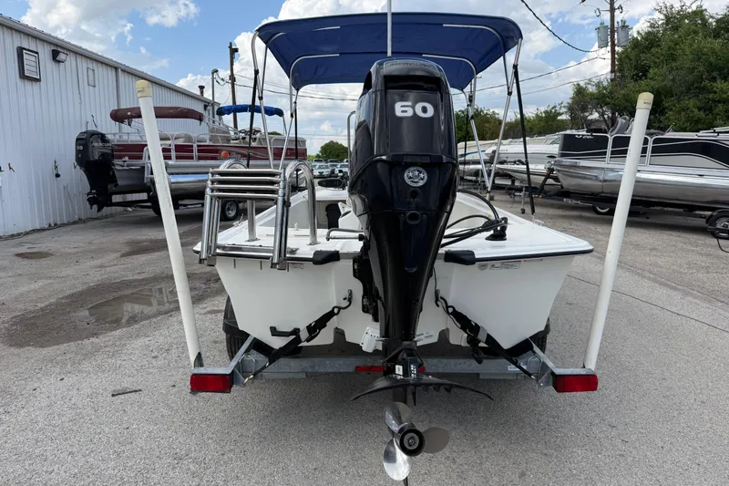 Slide: The Image of 2018 Mako Pro Skiff 17 CC with 60 HP outboard motor, parked on a trailer. - 10