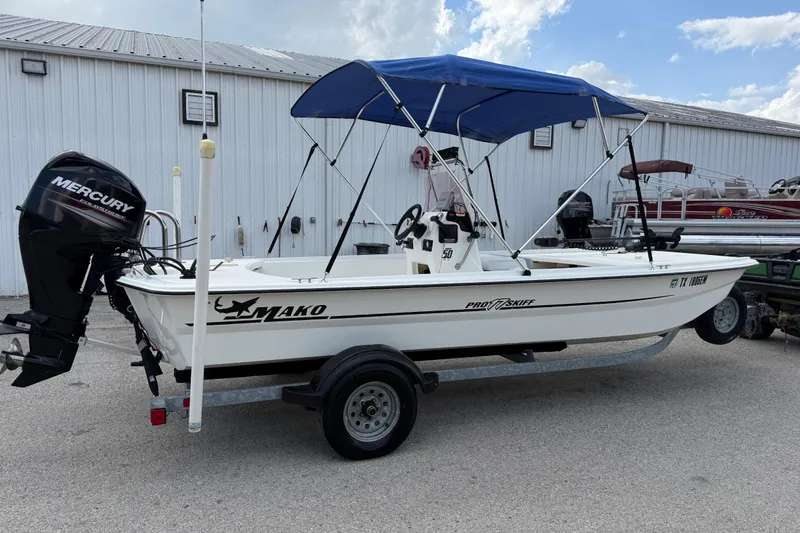 Slide: The Image of 2018 Mako Pro Skiff 17 CC boat with Mercury engine and blue canopy. - 13