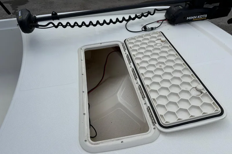 Slide: The Image of Open storage compartment on 2018 Mako Pro Skiff 17 CC boat deck with Minn Kota trolling motor. - 20