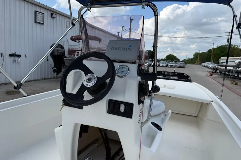 Slide: The Image of 2018 Mako Pro Skiff 17 CC boat interior with steering wheel and Garmin device. - 24