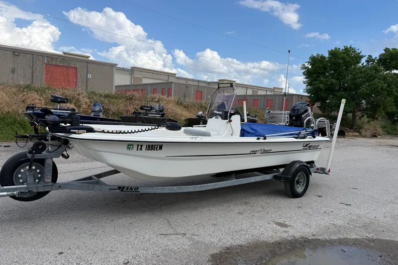 Slide: The Image of 2018 Mako Pro Skiff 17 CC boat on trailer, parked outdoors under blue sky. - 34