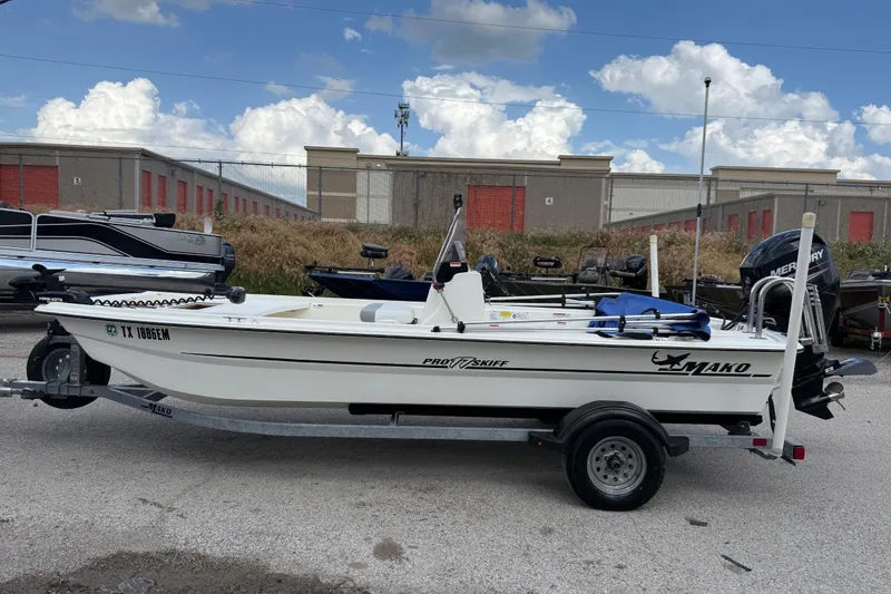 Slide: The Image of 2018 Mako Pro Skiff 17 CC boat on trailer, parked outdoors under blue sky. - 35