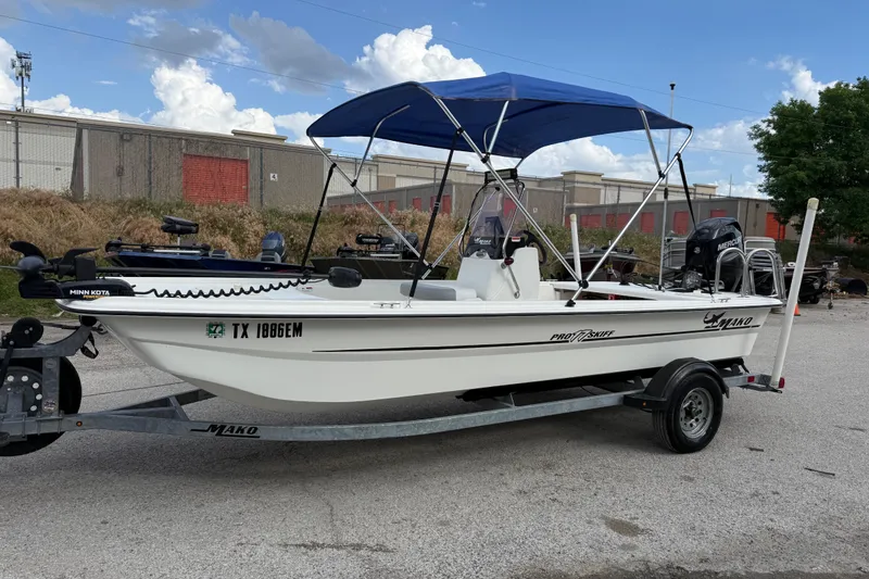 Slide: The Image of 2018 Mako Pro Skiff 17 CC boat on trailer with blue canopy and Minn Kota motor. - 4