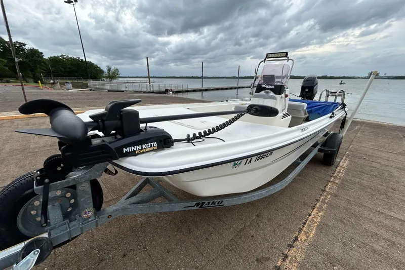 Slide: The Image of 2018 Mako Pro Skiff 17 CC boat by the water with Minn Kota motor. - 42