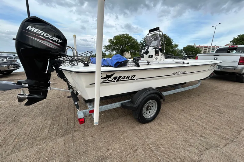 Slide: The Image of 2018 Mako Pro Skiff 17 CC boat on trailer with Mercury outboard motor. - 44