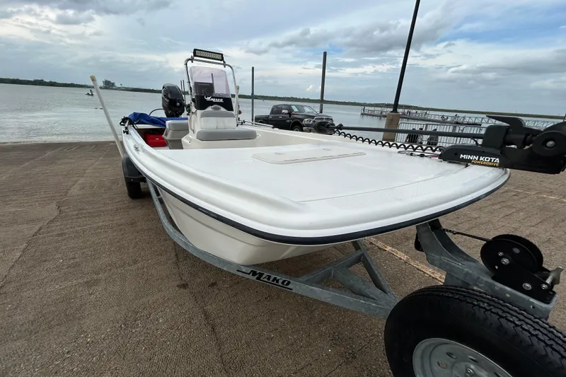 Slide: The Image of 2018 Mako Pro Skiff 17 CC boat on trailer by the water. - 46