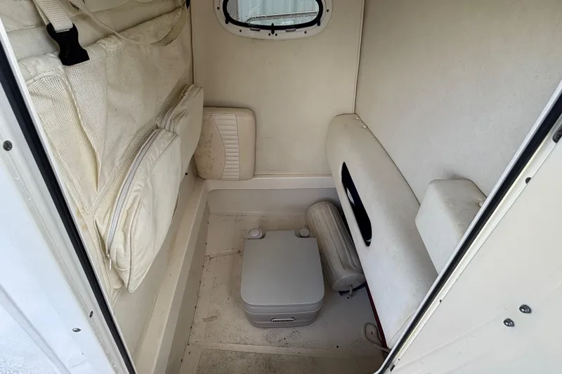 Slide: The Image of Interior cabin of 2005 Boston Whaler 220 Dauntless with storage and portable toilet. - 13