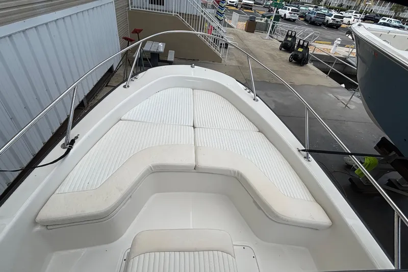 Slide: The Image of 2005 Boston Whaler 220 Dauntless boat with cushioned seating and stainless steel railings. - 15