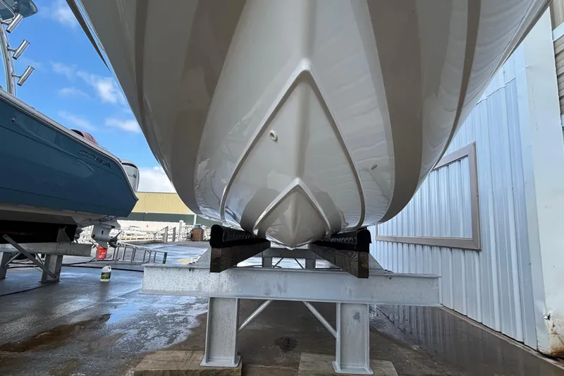 Slide: The Image of 2005 Boston Whaler 220 Dauntless boat hull on a metal stand, side view. - 2