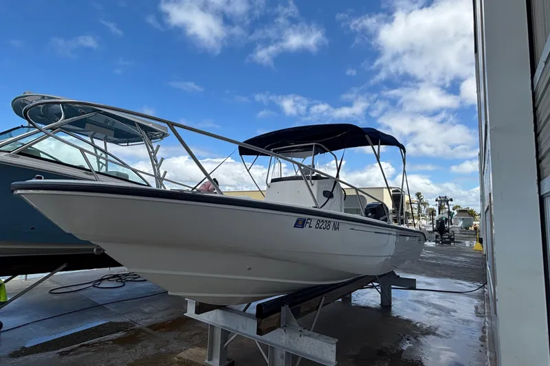 Slide: The Image of 2005 Boston Whaler 220 Dauntless boat on a dock under a blue sky. - 4