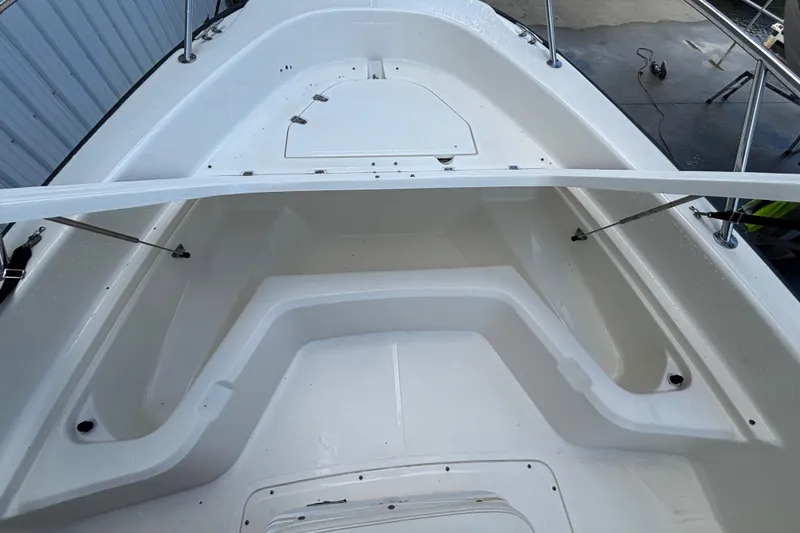 Slide: The Image of 2005 Boston Whaler 220 Dauntless boat interior, showcasing spacious seating and storage area. - 7