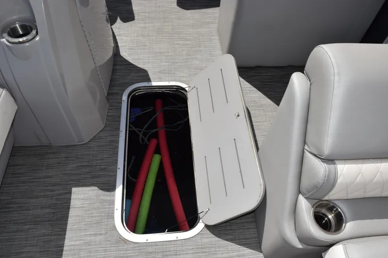 Slide: The Image of 2021 Bennington L 23 Swingback boat interior with open storage compartment and pool noodles. - 13