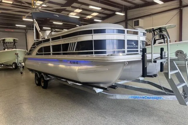 Slide: The Image of 2021 Bennington L 23 Swingback pontoon boat on trailer in indoor showroom. - 18
