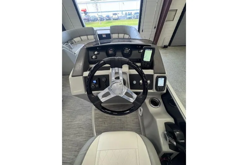 Slide: The Image of 2021 Bennington L 23 Swingback boat dashboard with steering wheel and navigation controls. - 19
