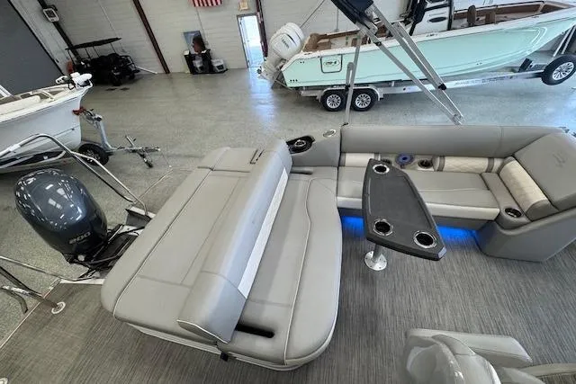 Slide: The Image of 2021 Bennington L 23 Swingback pontoon boat interior with seating and table in showroom. - 21