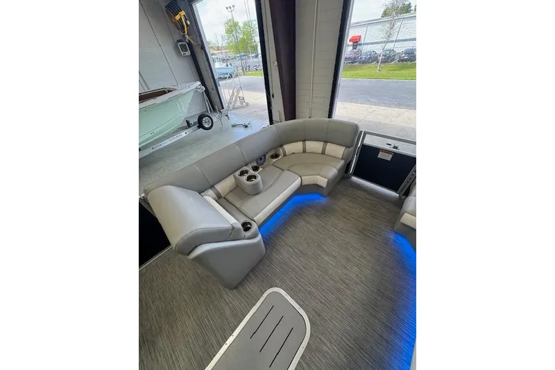 Slide: The Image of Luxurious interior of 2021 Bennington L 23 Swingback pontoon boat with plush seating and blue lighting. - 25