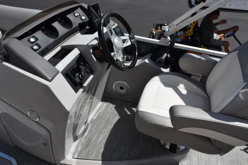 Slide: The Image of 2021 Bennington L 23 Swingback boat interior with steering wheel and captain's chair. - 8